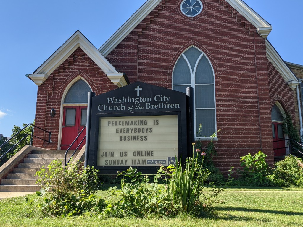 image of the church building and sign. The sign reads "Peacemaking is everybody's business."